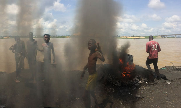 Nhiều trẻ em tham gia làm việc trong một lò mổ và chế biến thịt hun khói ở bang Bayelsa (Nigeria). Các em phải sử dụng lốp cao su, dây điện, lon nhôm để hun khói thịt. 