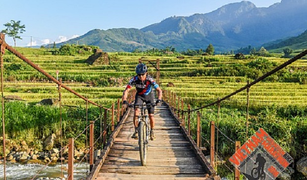 A biker passes a bridge in Sa pa District in Vietnam’s northern mountainous province of Lao Cai. Vietnam Mountain Bike Marathon