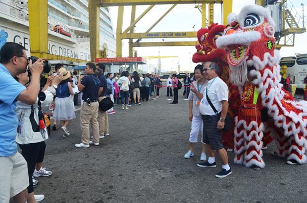  Some cruise ship passengers taking photos with local lion dancers after the welcoming ceremony