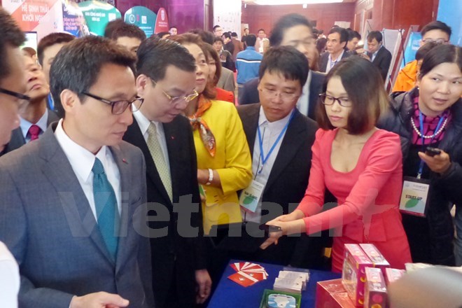 Deputy Prime Minister Vu Duc Dam (left) visits a booth at the event. Photo: VNA