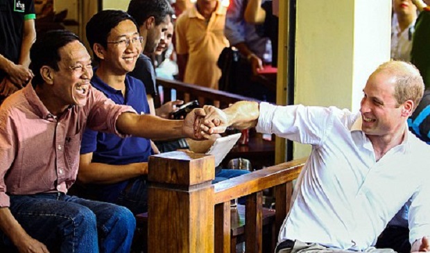 Prince William, Duke of Cambridge, shakes hands with a local while having coffee at a roadside café on Thuoc Bac Street in Hanoi’s Old Quarter on November 16, 2016. Tuoi Tre