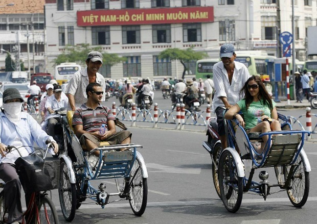 Foreign tourists enjoy a cyclo tour in Ho Chi Minh City. Photo by AFP/Hoang Dinh Nam