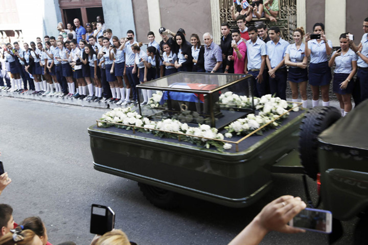 Người dân dùng điện thoại di động ghi lại hình ảnh đoàn xe chở di cốt Fidel. Ảnh: USA Today.