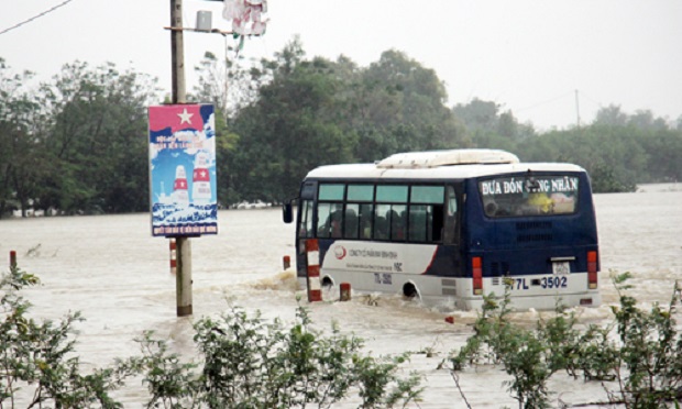 A bus struggles along a flooded road in Binh Dinh Province (Photo: VnExpress)