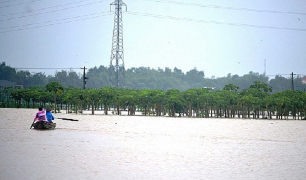 Local residents paddle through a flooded area in the central Vietnamese province of Quang Nam on December 3, 2016. Tuoi Tre