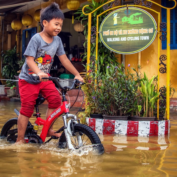   A child cycling through the floodwaters