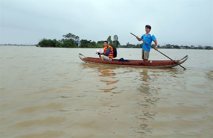 Residents in Binh Dinh Province use boat to travel in flooded affected areas. 