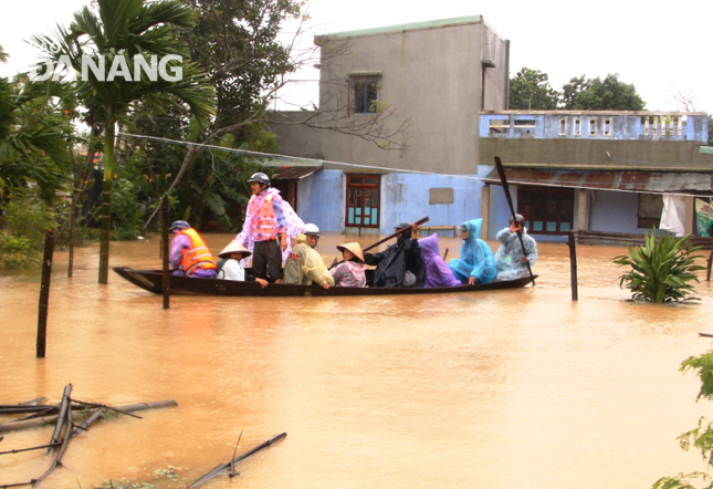 Người dân thôn La Bông, xã Hòa Tiến dùng xuồng để di tản người già, trẻ em, phụ nữ đến nơi trú ẩn an toàn