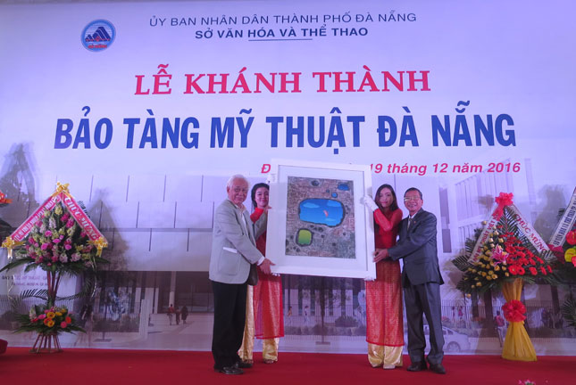 Painter Tran Khanh Chuong (left), Director of the Viet Nam Fine Arts Museum, presenting a painting to the Da Nang Fine Arts Museum
