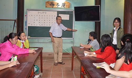 Abe Toru teaches Japanese to young students in Hoi An