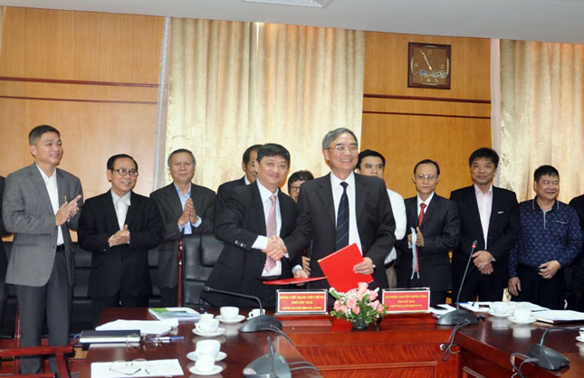 Vice Chairman Dung (left) shaking hands with a VAST representative at the signing ceremony