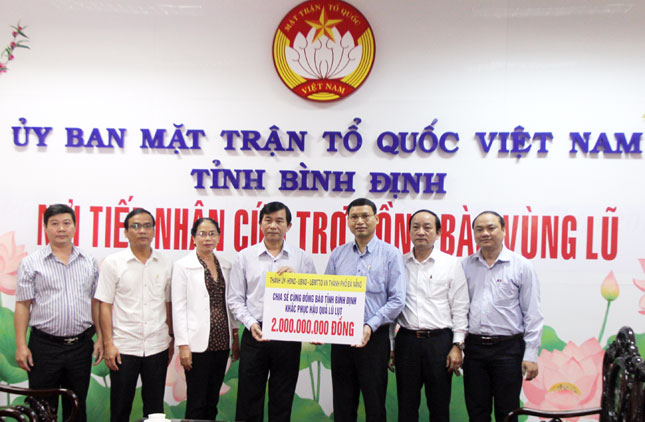 Phó Chủ tịch UBND thành phố Đà Nẵng Hồ Kỳ Minh (thứ 3 từ phải qua)  trao hỗ trợ tỉnh Bình Định số tiền 2 tỷ đồng.