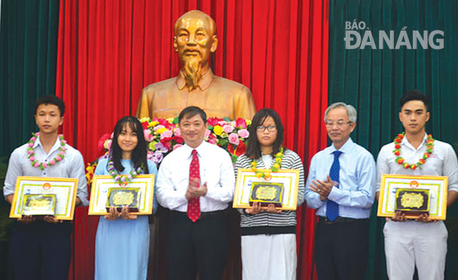 Phó Chủ tịch UBND thành phố Đặng Việt Dũng trao thưởng cho các em đạt giải thưởng Khuyến tài Huỳnh Thúc Kháng năm học 2015 - 2016.                                     Ảnh: Phương Trà