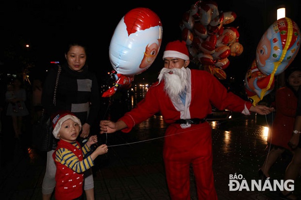      Santa Claus presenting a Christmas gift to a kid at an entertainment centre