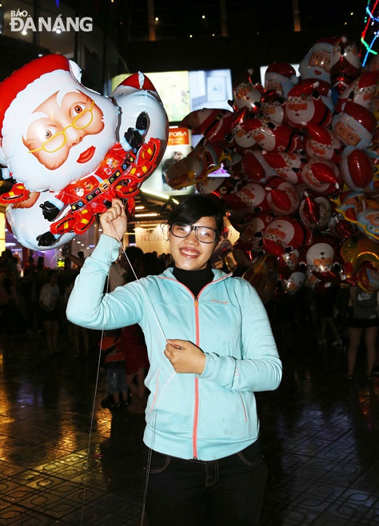 A lady taking photos with a gift from Santa Claus