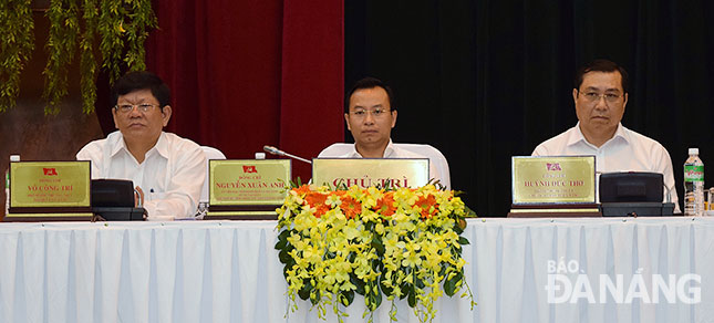 Secretary Anh (centre), Deputy Secretary Tri (left) and municipal People’s Committee Chairman Huynh Duc Tho (right) at the meeting