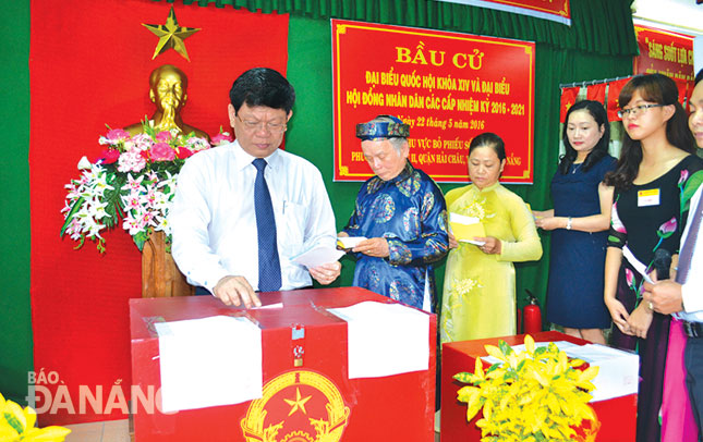 Municipal Party Committee Deputy Secretary Vo Cong Tri (left) participating in the elections for the 14th National Assembly (NA) and all-level PCls of the 2016 – 2021 in Hai Chau District’s Hai Chau 2 Ward