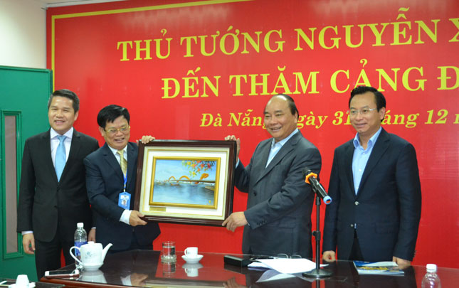  Prime Minister Phuc (2nd right), along with Secretary Anh (1st right) presenting a momento to a representative from the company