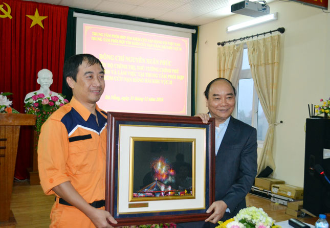 Prime Minister Phuc (right) presenting a momento to a representative from the centre