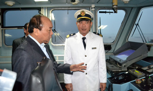 Prime Minister Phuc (left) speaking to a crew member on board the ship