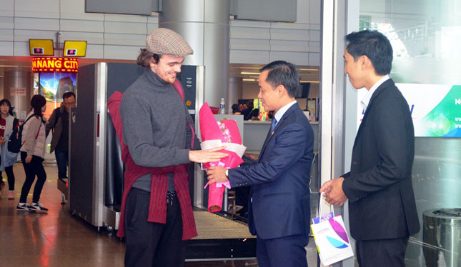 Deputy Director Binh (centre) presenting flowers to an international air passenger