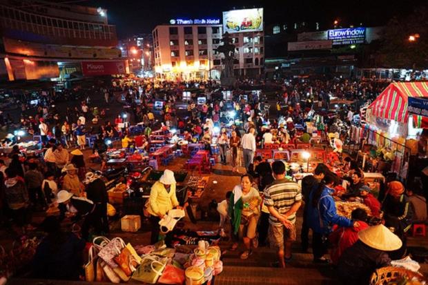 Da Lat Night Market - Visitors can find random shirts and warm clothes at the market, but it's really a place for foodies with a wide choice on the menu such as warm fresh soymilk and artichoke tea, sweet tofu in ginger sauce, grilled scallops, chicken porridge, steamed corn and the banh trang nuong (grilled rice paper), especially with cheese. Photo by VnExpress. 