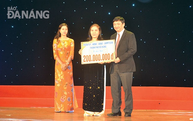 Vice Chairman Dung presenting the 200 million VND to a representative from DAVA