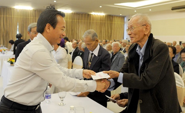 Secretary Anh (left) presenting a gift to a senior citizen