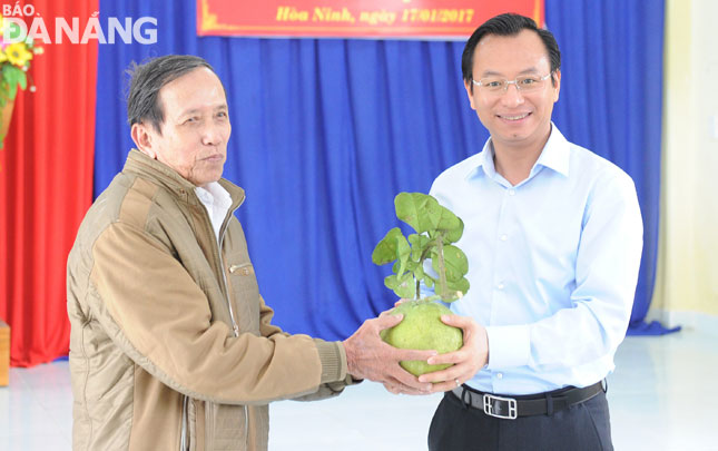  A Hoa ethic man (left) presenting a locally-grown pomelo to Secretary Anh