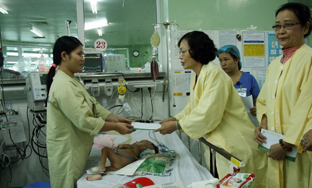 Chairwoman of the municipal Association of Charity and Children's Rights Protection, Ms Le Thi Tam, presenting Tet gifts to a relative of a patient at the Maternity and Paediatrics Hospital