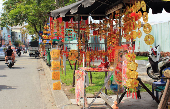 Nhiều gian hàng nhỏ bày bán phong bao lì xì, dây treo trang trí,…được dựng hai bên con đường Hùng Vương, tô thêm sắc đỏ thắm cho ngày Tết. Chỉ cần đi trên tuyến đường này là thấy không khí Tết đang ngập tràn mọi nơi.