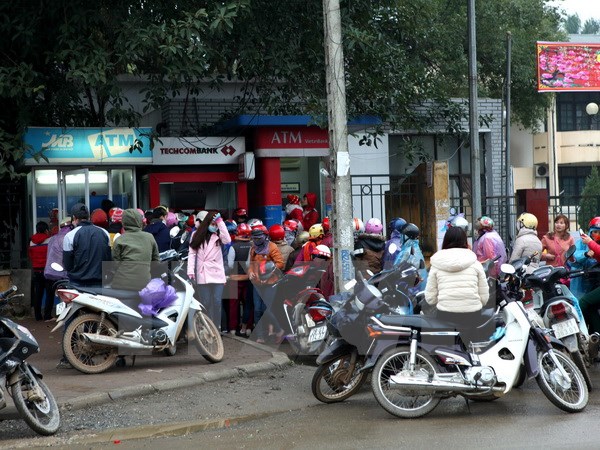 Cảnh xếp hàng chờ rút tiền tại các cây ATM trên đường Hòa Lạc, thị trấn Xuân Mai, Hà Nội. (Ảnh: Ngọc Hà/TTXVN)