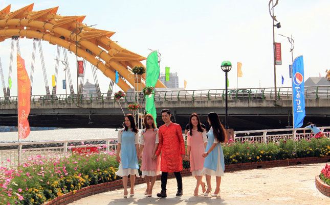 Local young people in renovated Ao Dai (Vietnamese Traditional Long Dress) shooting a photo on Bach Dang StreetLocal young people in renovated Ao Dai (Vietnamese Traditional Long Dress) shooting a photo on Bach Dang Street