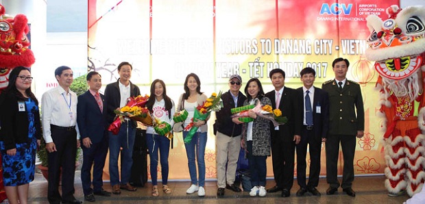 Representatives from the municipal Department of Tourism presenting flowers to first international passengers