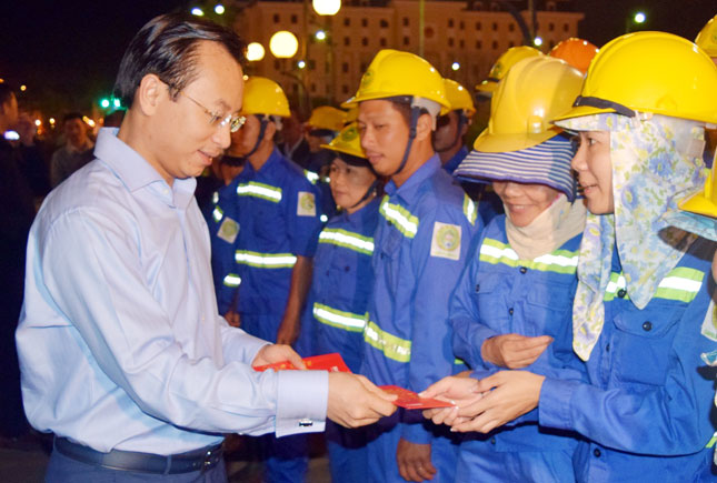 Secretary Anh (left) giving lucky money to sanitation workers at the flower market