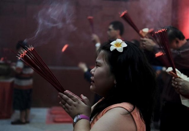 A child holds incense sticks at Dharma Sakti temple as she prays during the Lunar New Year, in Jakarta, Indonesia. (Reuters)