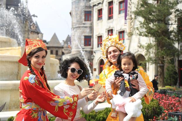 A child receiving lucky money from the resort’s staff members, dressed in God of Wealth outfits