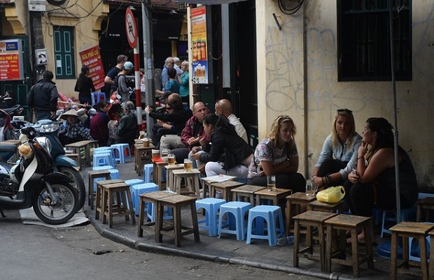 Foreign tourists enjoy food and drinks at small open-air restaurants in the ancient quarter of Hanoi. Photo by AFP