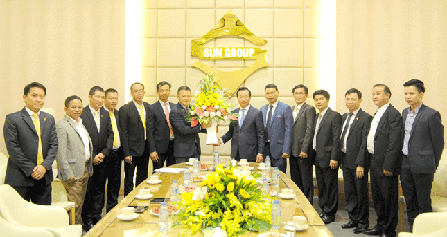 Secretary Anh (centre) presenting a bouquet of flowers to a Sun Group representative