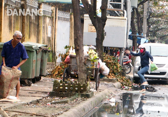 Vứt rác bừa bãi nên những ngày mưa, nước ứ đọng tại các điểm tập kết thùng rác gây ô nhiễm môi trường.	         Ảnh: NAM TRÂN