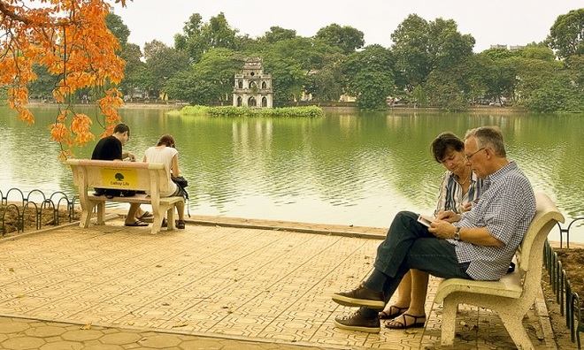 Foreigners are seen relaxing on a bench by Hanoi's iconic Hoan Kiem Lake. Photo by VnExpress Photo Contest/Nguyen Ngoc Luan