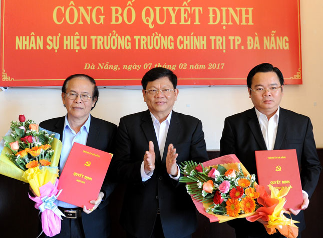 Phó Bí thư Thường trực Thành ủy Võ Công Trí  trao quyết định và tặng hoa chúc mừng đồng chí Lê Minh Trung (bìa phải) và đồng chí Nguyễn Linh (bìa trái).