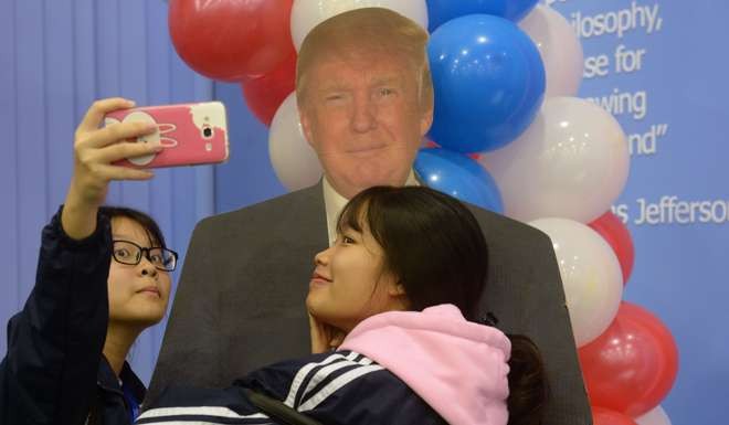 Vietnamese students take a selfie with a paper model of Donald Trump during an election watch event at the U.S. embassy in Hanoi last November. Photo by AFP 