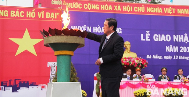   Chairman of Hoa Vang District People’s Commitee, Tran Van Truong, lighting a torch at a departure point ...