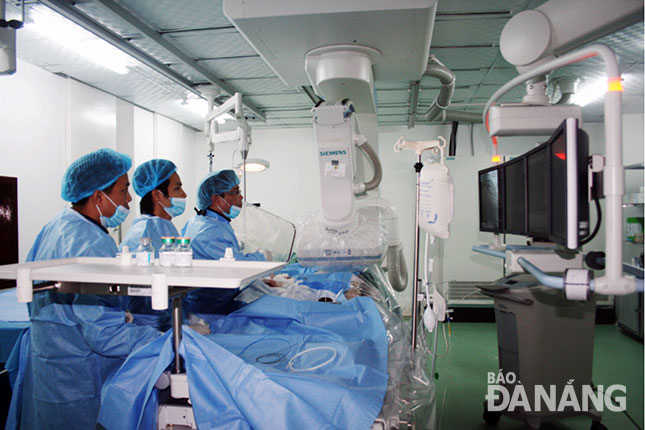 TS - bác sĩ Hoàng Phương (bìa phải) cùng kíp mổ trong một ca phẫu thuật với các thiết bị mới, tiên tiến. 