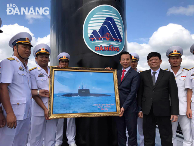 Crew members presenting a picture of HQ-186 Da Nang to the city leaders