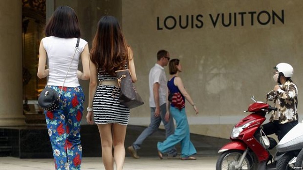Women walk next to a Louis Vuitton sign as they enter the luxury Trang Tien Plaza shopping mall in Hanoi. Photo by Reuters/Kham