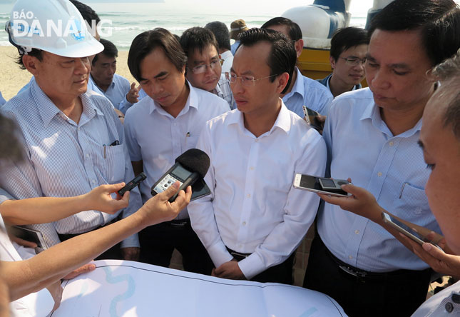 Ông Xuân Anh (áo trắng) lắng nghe các thông tin về tình hình sạt lở tại bờ biển Đà Nẵng