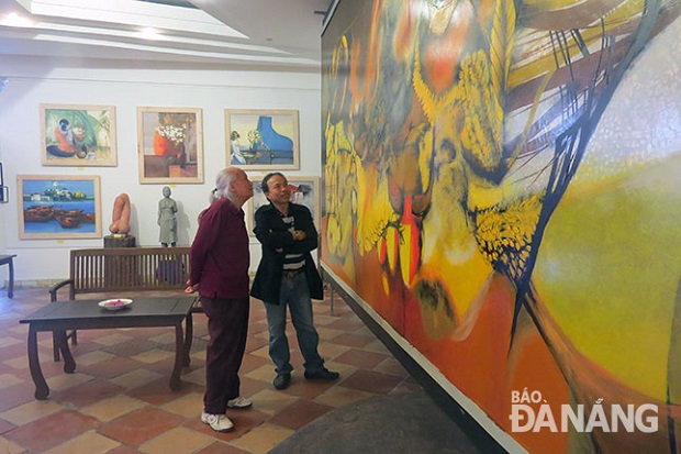 Artist Vu Trong Thuan (left) at his gallery