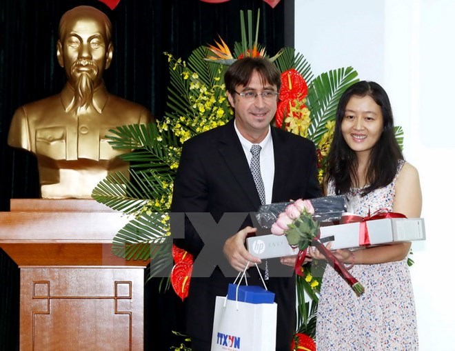 Director for the Asia-Pacific of the OIF Eric-Normand Thibeault (L) presents the first prize of the the Young Francophone Reporters contest in 2016 (Photo: VNA)